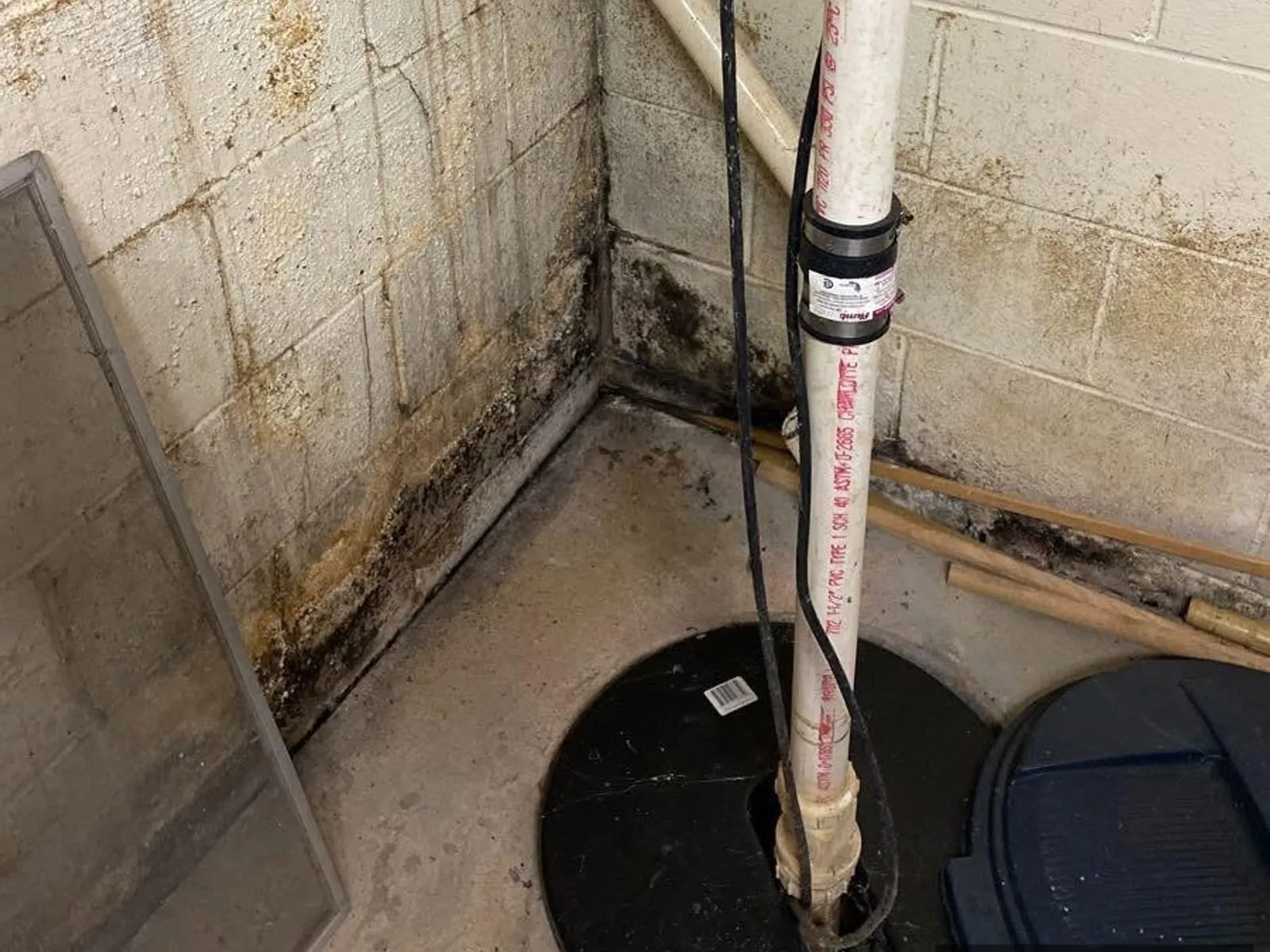 Stone basement wall with a moisture stain along a pipe run
